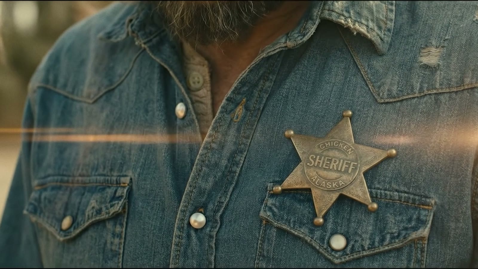 A sheriff's badge on a denim shirt