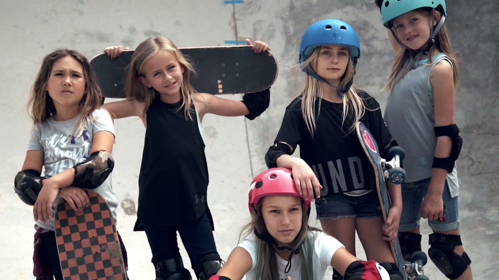 A group of girl skaters in helmets and pads